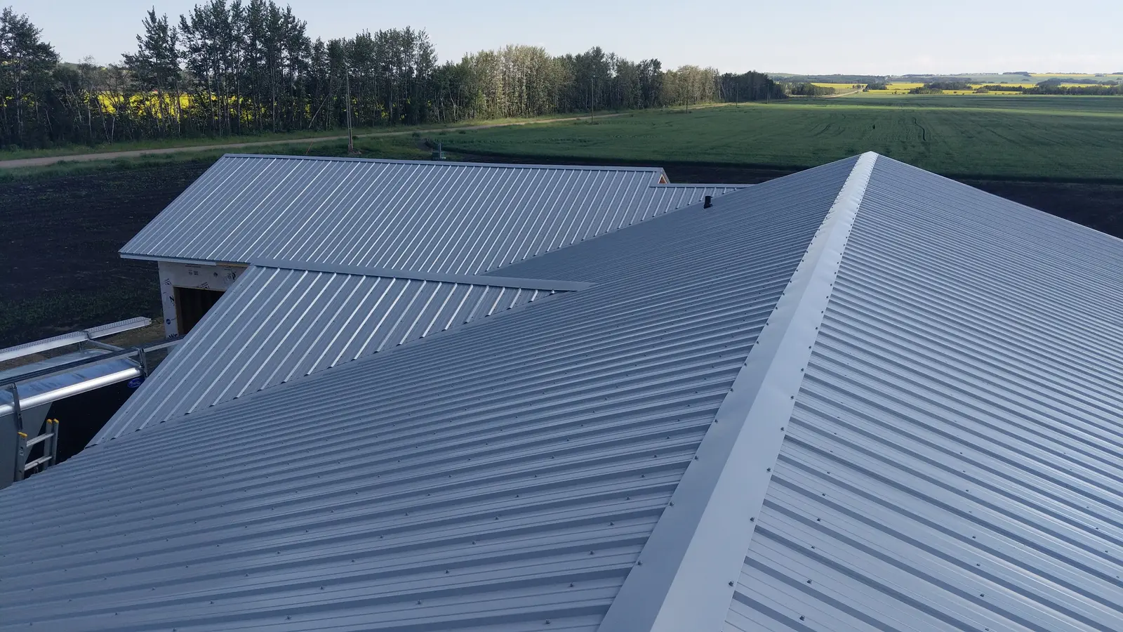 Galvalume standing-seam metal across multiple gables on a Central Alberta acreage